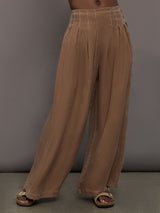 Model is wearing the Coconut cupro pleated wide leg pant, front view.