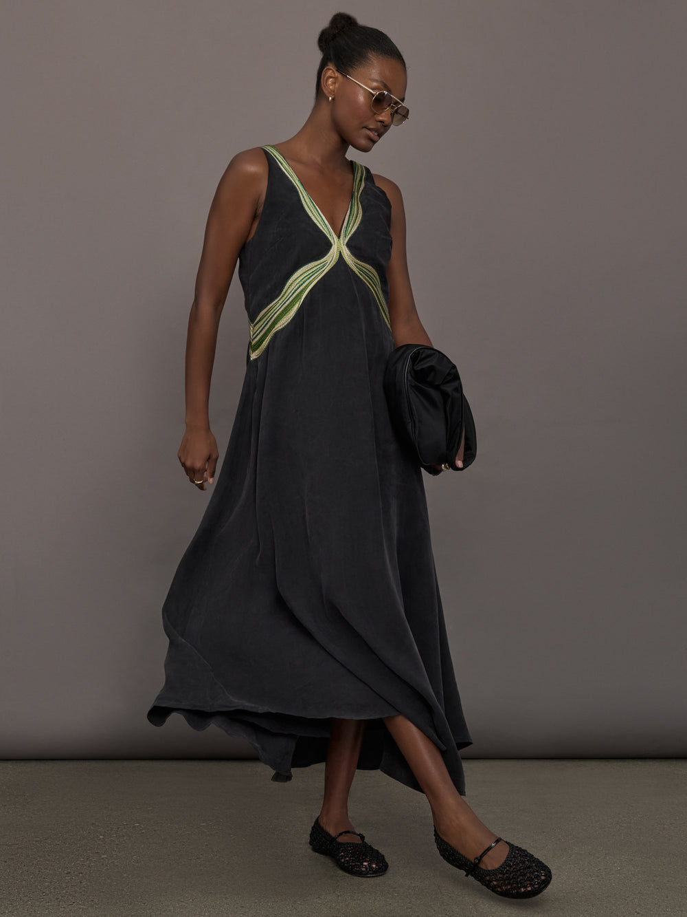 Model is wearing the Onyx embroidered cupro maxi dress walking, full body view.