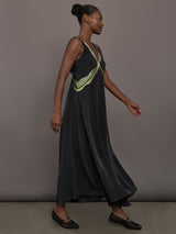 Model is wearing the Onyx embroidered cupro maxi dress, side walking view.