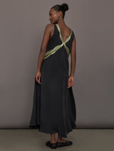 Model is wearing the Onyx embroidered cupro maxi dress, back view.