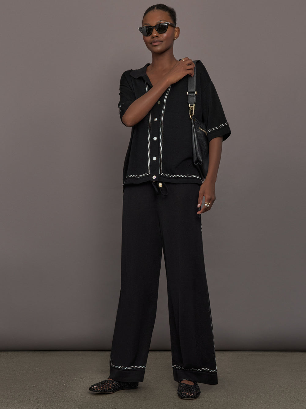 Model is wearing the Coco Knit Shirt Ink, full body view with matching knit pants.
