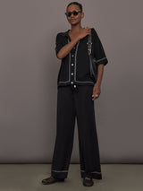 Model is wearing the Coco Knit Shirt Ink, full body view with matching knit pants.