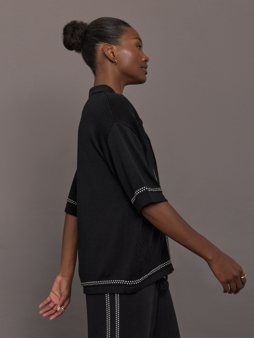 Model is wearing the Coco Knit Shirt Ink, side view highlighting sleeve and border detail.
