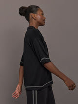 Model is wearing the Coco Knit Shirt Ink, side view highlighting sleeve and border detail.