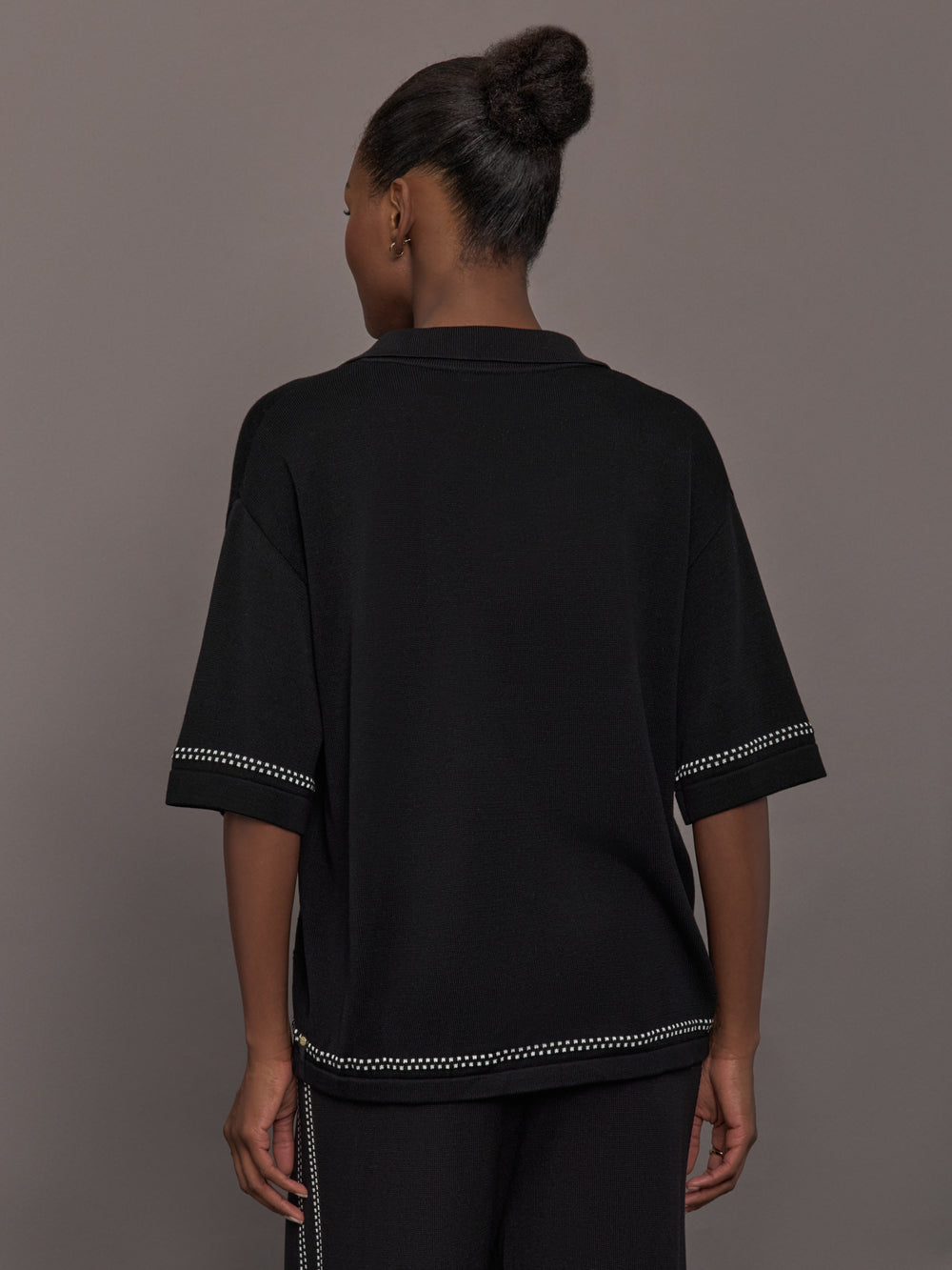 Model is wearing the Coco Knit Shirt Ink, back view showing relaxed fit and hem detail.