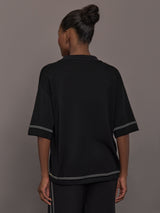 Model is wearing the Coco Knit Shirt Ink, back view showing relaxed fit and hem detail.