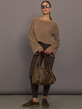 Model is wearing a taupe plush long-sleeve top with wide bell sleeves, styled with leopard print leggings, brown sneakers, oversized sunglasses, and an olive shoulder bag, front full body view.