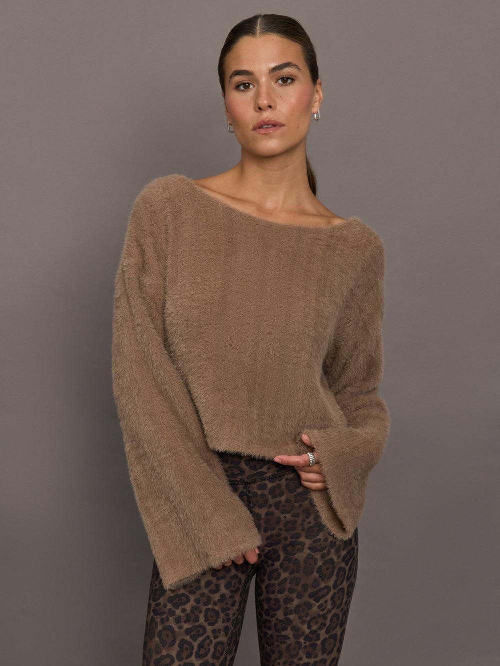 Model is wearing a taupe plush long-sleeve top with wide bell sleeves and relaxed fit, front view.