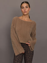 Model is wearing a taupe plush long-sleeve top with wide bell sleeves and relaxed fit, front view.
