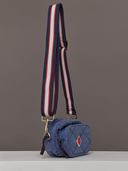 The Pacific Voyage Crossbody Bag in blue features a compact, structured design with a red, white, and blue adjustable strap.
