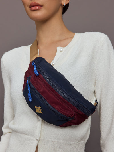 Multicolored crossbody bag with a beige strap.