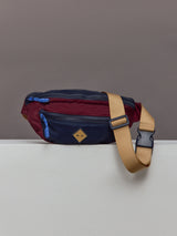 Multicolored crossbody bag with a beige strap.