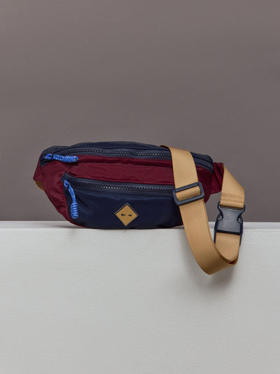 Multicolored crossbody bag with a beige strap.