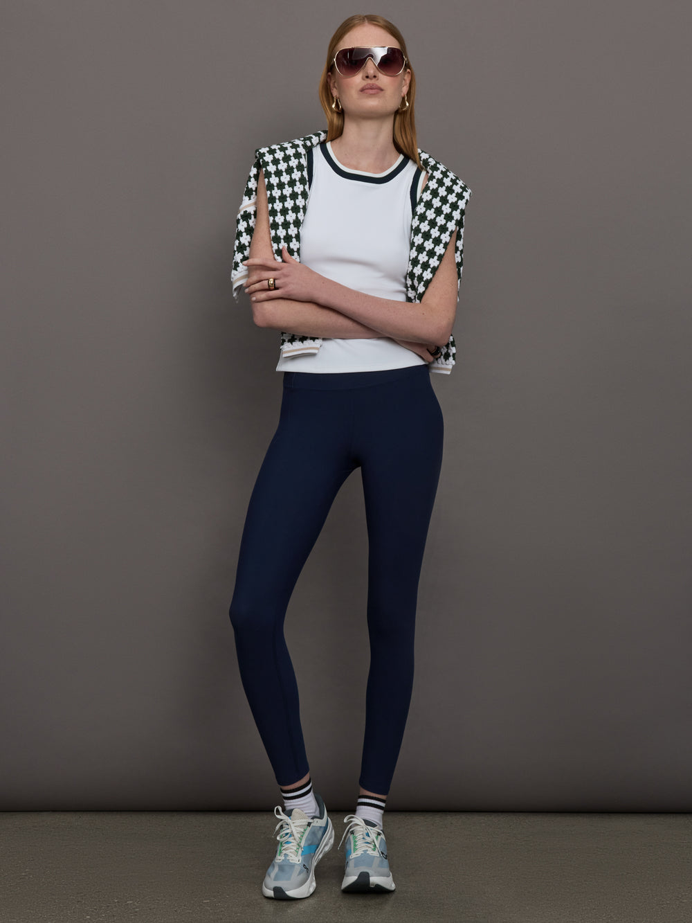 Model wears a white tank top with green trim, perfect for tennis. 