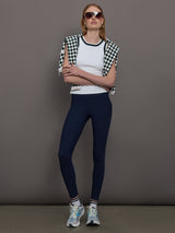 Model wears a white tank top with green trim, perfect for tennis. 