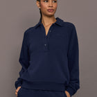 Model is wearing Collared Elle Polo in navy, front view with button placket.