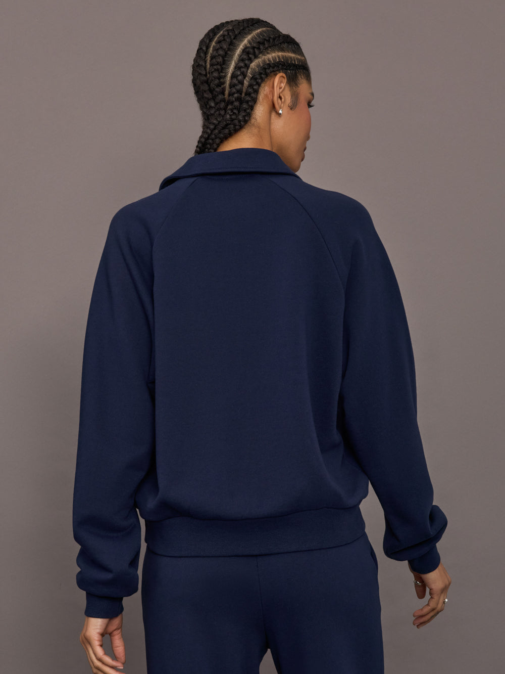 Model is wearing Collared Elle Polo in navy, back view with long sleeve silhouette.