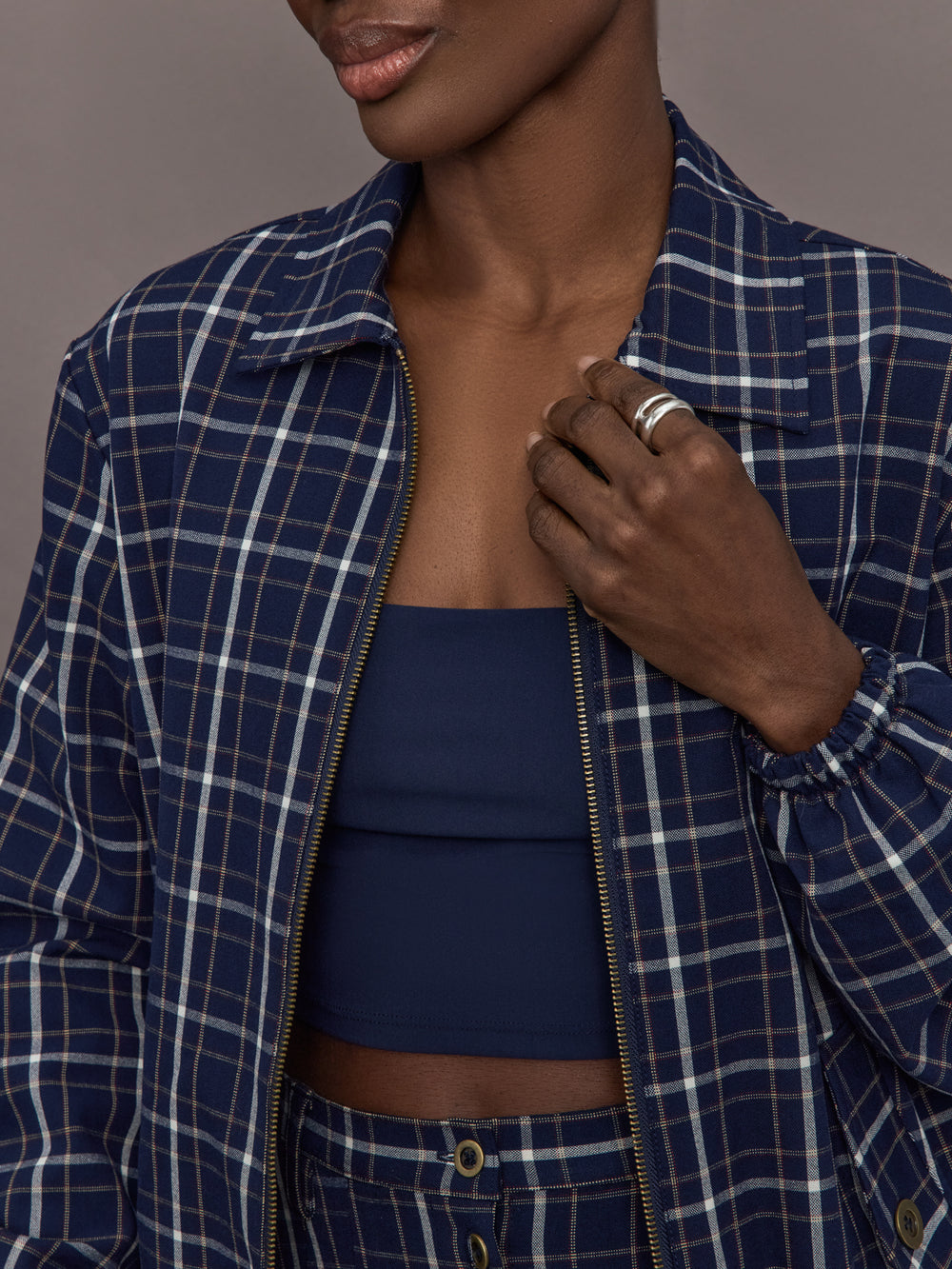 Model is wearing Check Jacquard Zip-Front Bomber Jacket in Navy, zipper close-up.