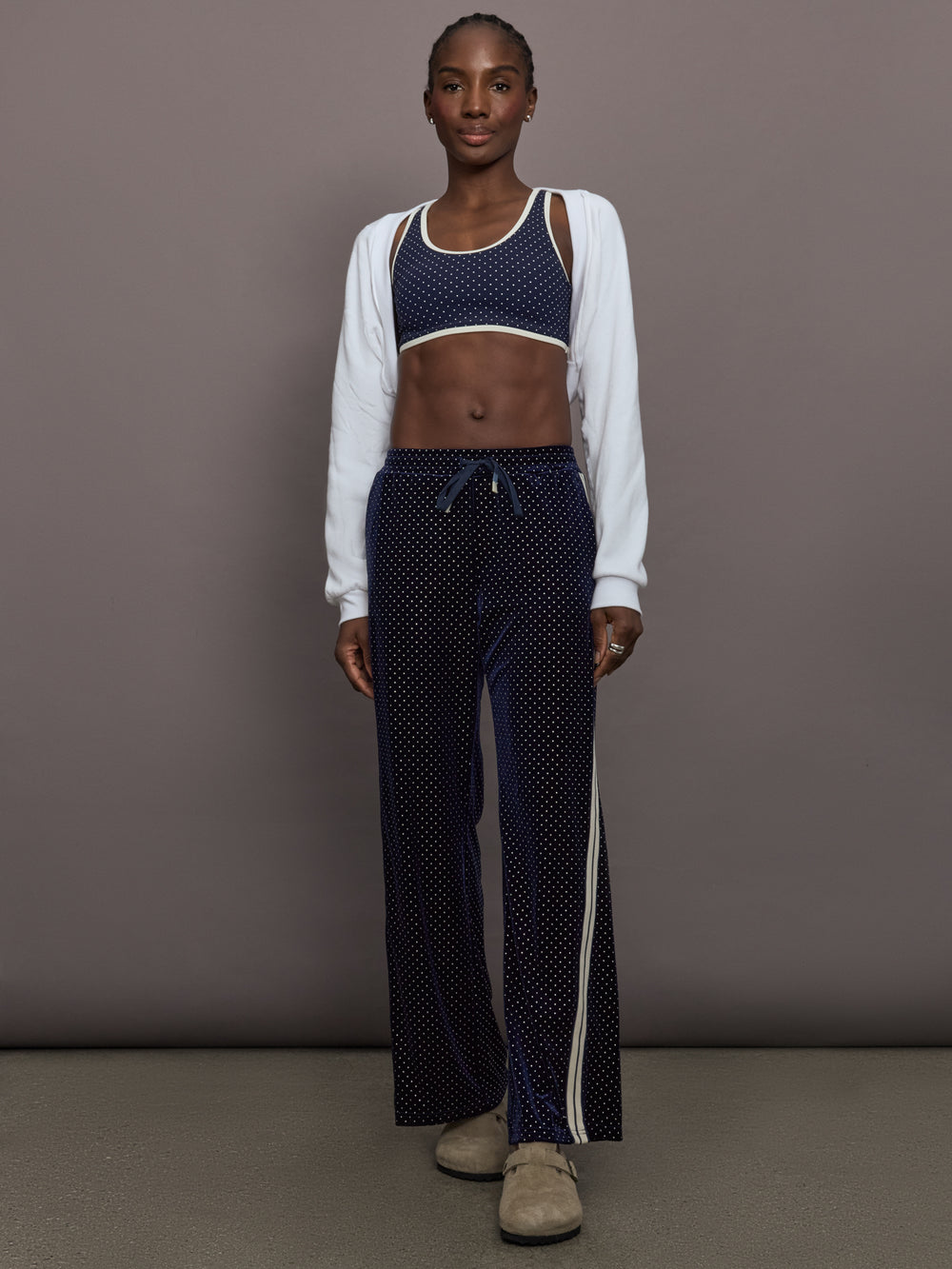 Model is wearing Spellbound Racerback Sports Bra in Polka Dot, full body view.