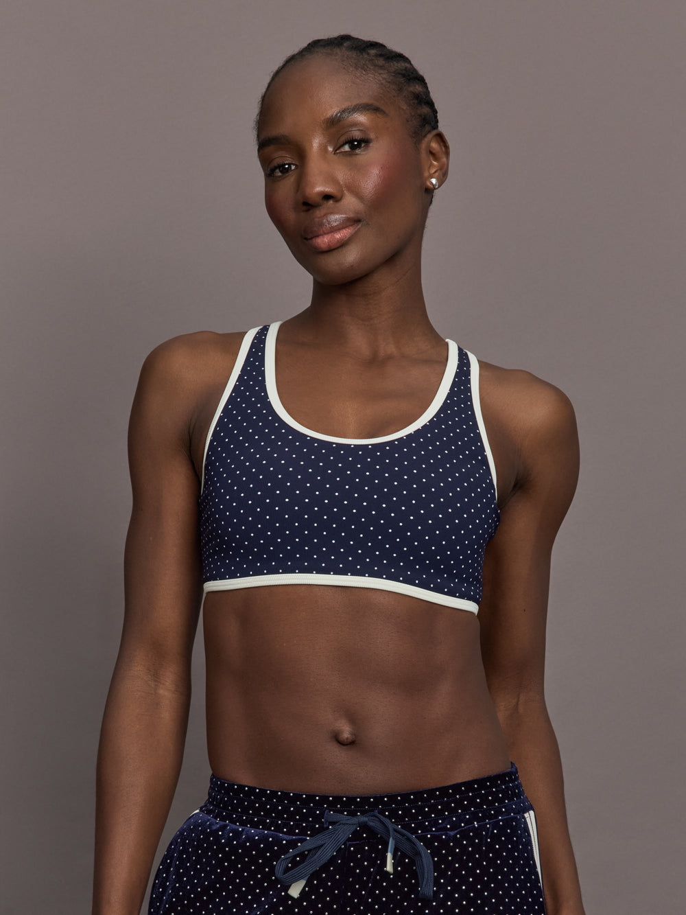 Model is wearing Spellbound Racerback Sports Bra in Polka Dot, front view.
