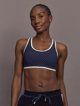 Model is wearing Spellbound Racerback Sports Bra in Polka Dot, front view.