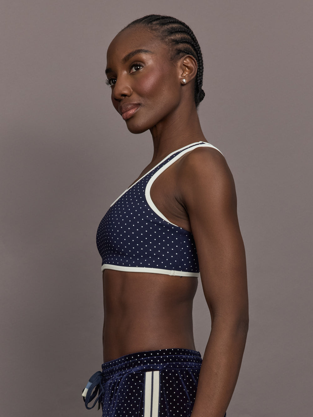Model is wearing Spellbound Racerback Sports Bra in Polka Dot, side view.