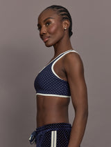 Model is wearing Spellbound Racerback Sports Bra in Polka Dot, side view.