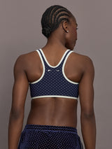 Model is wearing Spellbound Racerback Sports Bra in Polka Dot, back view.
