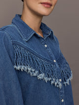 Model wears the Wildwest Style Fringe Shirt in blue denim with classic western-inspired fringe detailing across the chest and back and a button-up front.