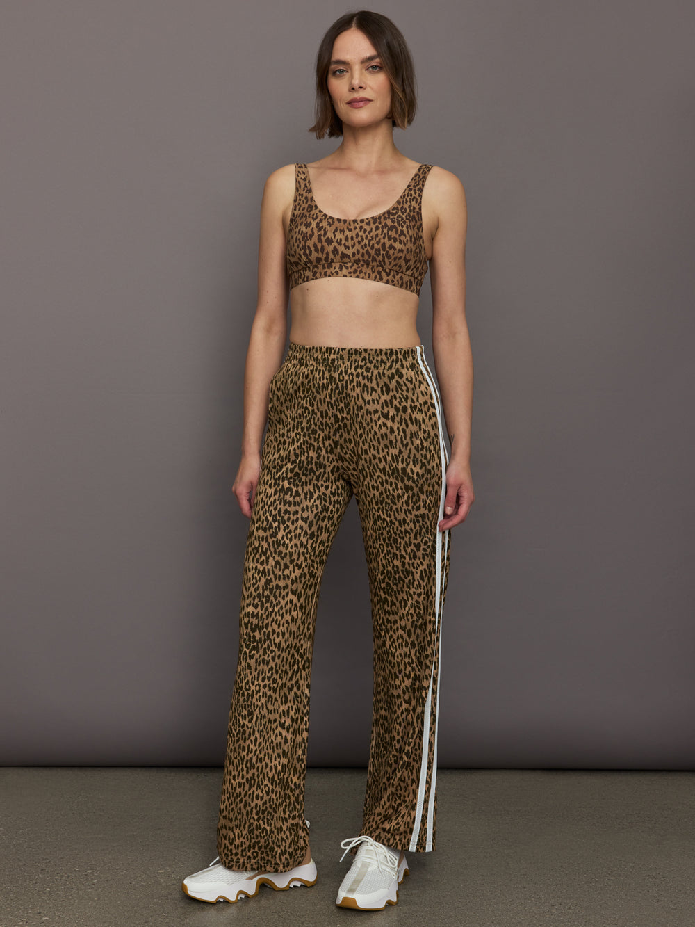 Model wears relaxed-fit pants with animal print, two white stripes down the side and an elastic waistband.