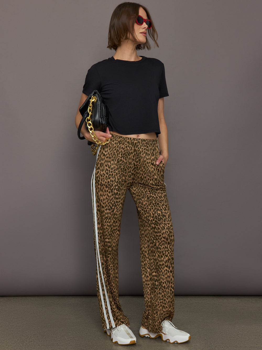 Model wears relaxed-fit pants with animal print, two white stripes down the side and an elastic waistband.