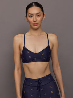 Model wearing a navy blue sports bra with a subtle pattern.