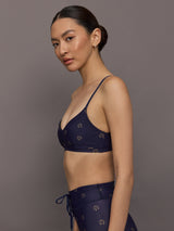 Model wearing a navy blue sports bra with a subtle pattern.
