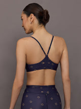 Model wearing a navy blue sports bra with a subtle pattern.