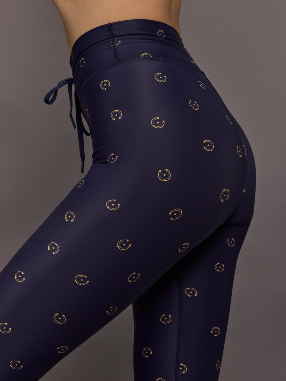 Model wears navy leggings with a subtle horseshoe pattern.