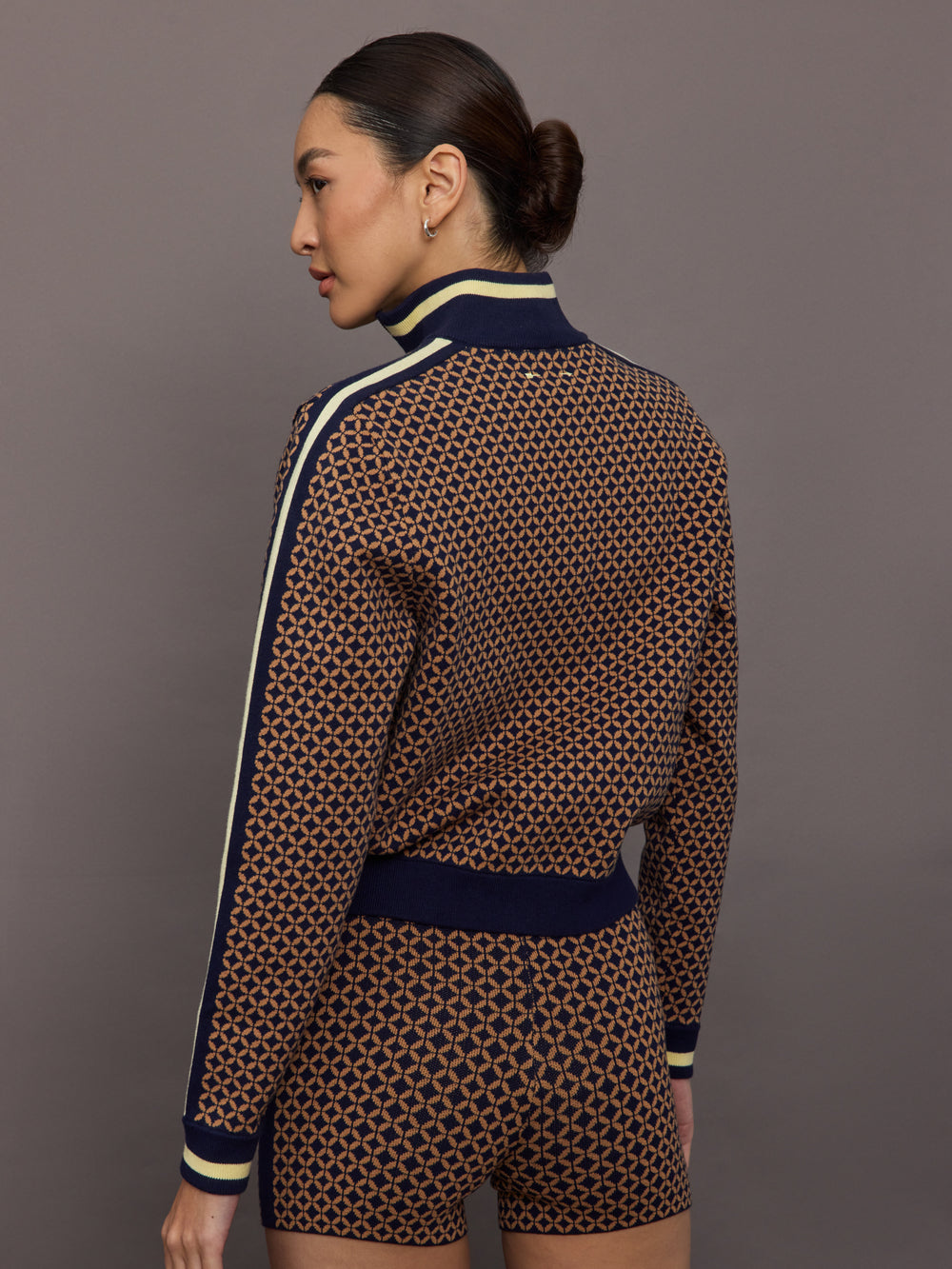 Model wearing a geometric patterned track jacket.