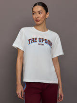 Person wearing a white t-shirt with 'The Upside Sport' text on a gray background