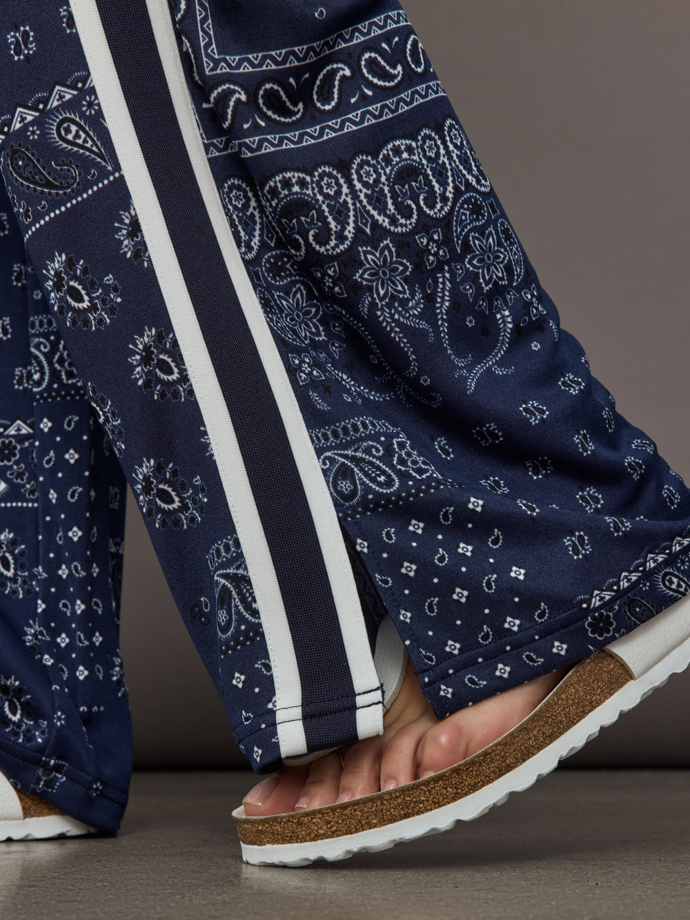 Model wears the Vaquero Roma Pant in Paisley with a relaxed, loose-fitting silhouette and an intricate paisley print.