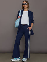 Model wears classic navy double-breasted blazer featuring structured shoulders and leopard detailing inside.