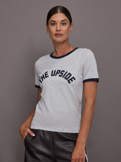 Woman wearing a gray t-shirt with 'THE UPSIDE' text on a plain background