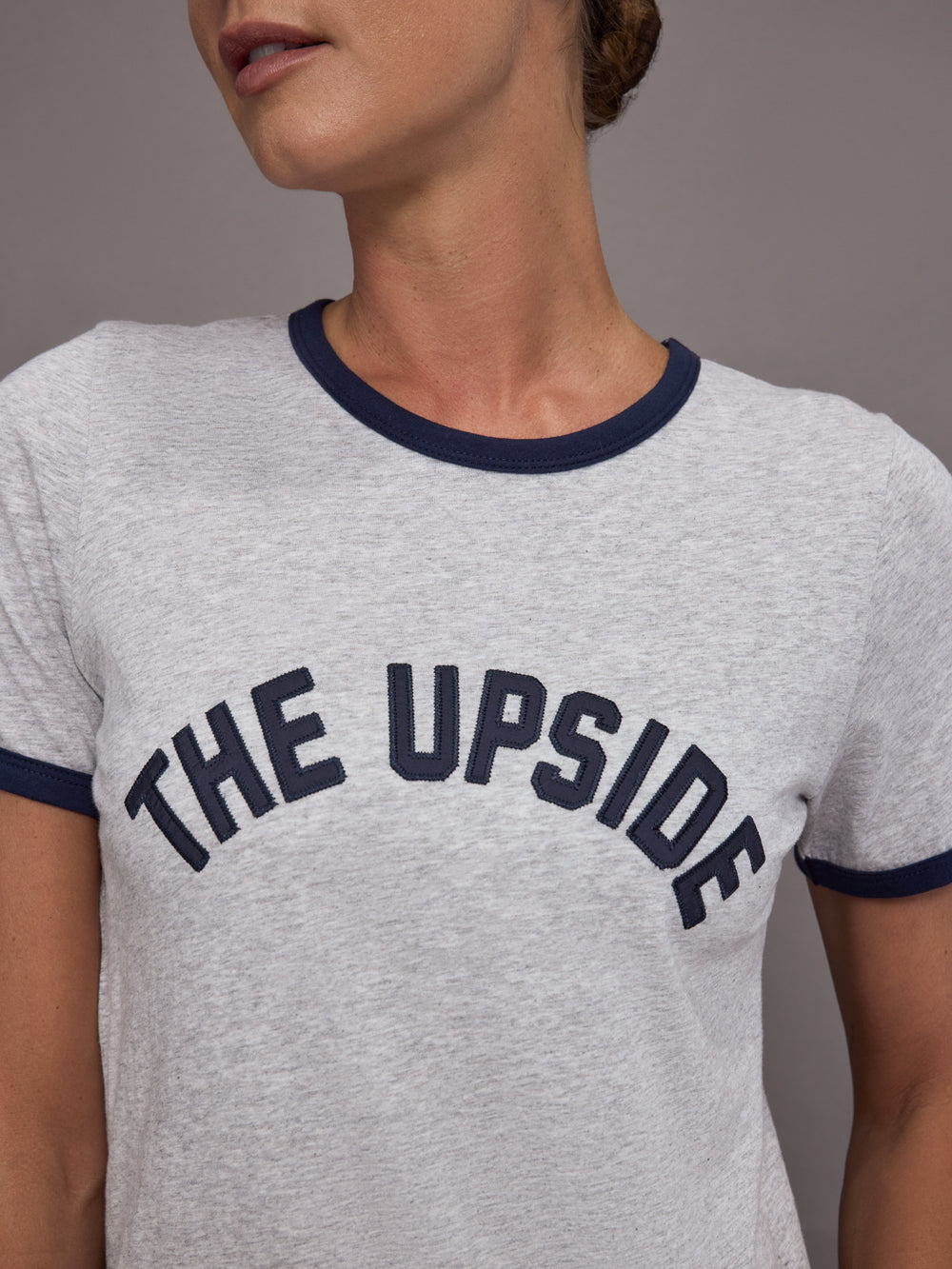 Gray t-shirt with 'THE UPSIDE' text on a person against a gray background