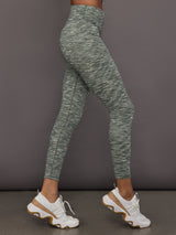 Green marbled leggings worn by a person on a gray background
