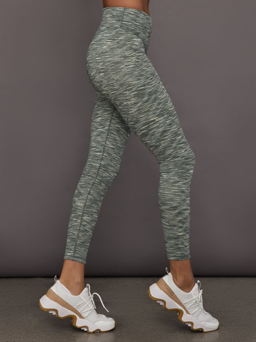 Green marbled leggings worn by a person on a gray background