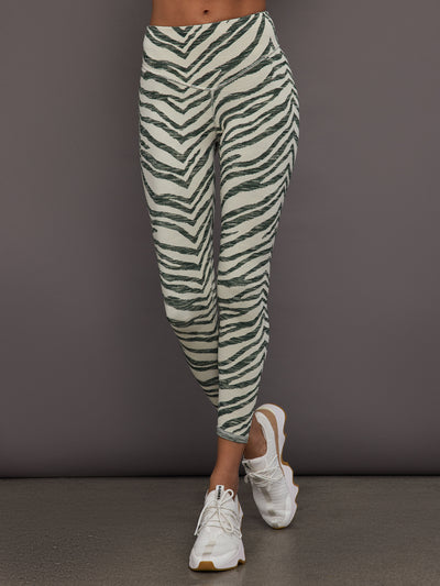 Person wearing zebra print leggings against a gray background