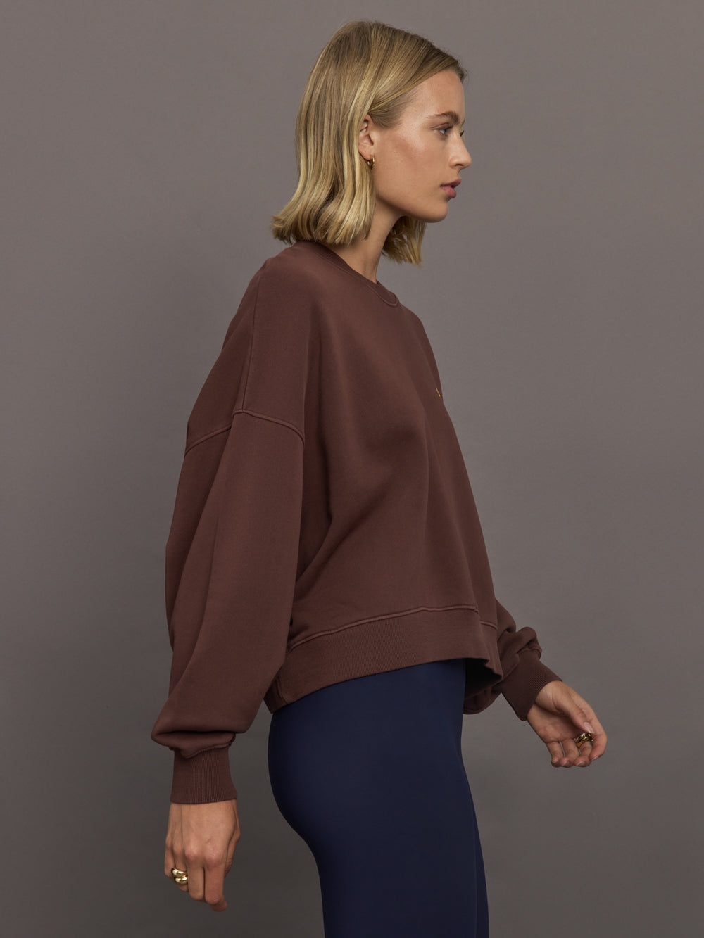 Model wearing a brown sweatshirt with 'The Upside' logo