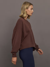 Model wearing a brown sweatshirt with 'The Upside' logo