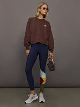 Model wearing a brown sweatshirt with 'The Upside' logo