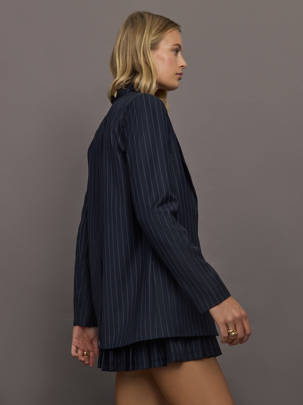 Model wearing a navy pinstripe blazer