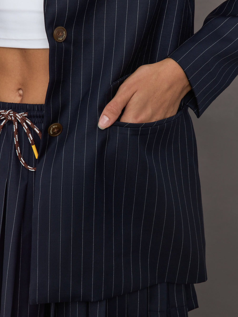 Model wearing a navy pinstripe blazer