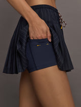 Model wearing a navy pleated skirt with stripes